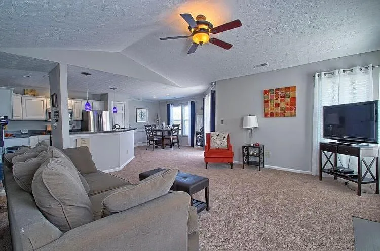 Spacious living room with vaulted ceilings, wood burning fireplace, and plenty of natural light.