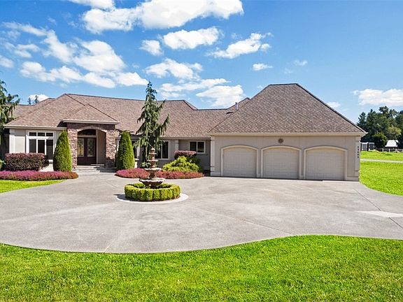 Circular drive features water feature that stays. 3 car oversized garage & Presidential roof!