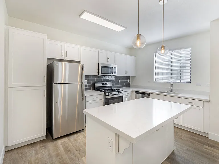 Experience the epitome of modern elegance at The Michael B apartments, where sleek white cabinetry meets state-of-the-art stainless steel appliances, setting the stage for gourmet culinary adventures.