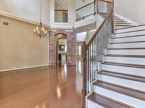 Entry features grand staircase, high ceilings, and wood flooring