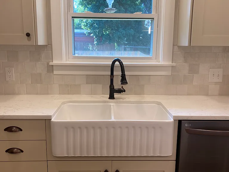 Farm sink with black faucet.