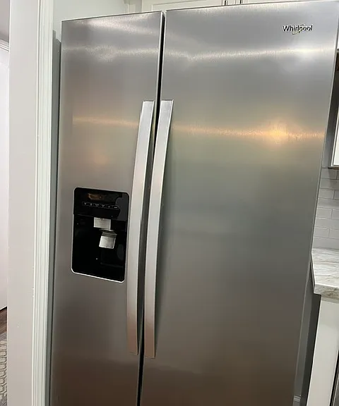Fridge with water and ice on the door.