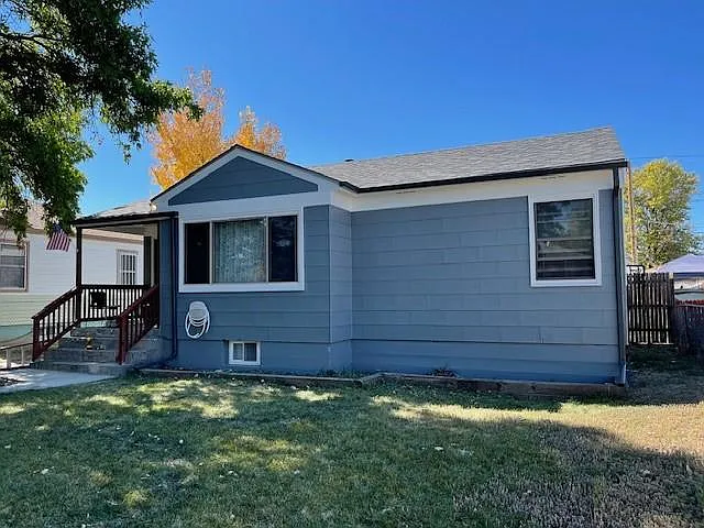 front of house with 2 large shade trees