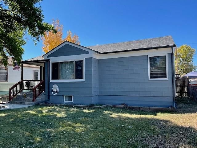 front of house with new roof, eaves and gutters and 2 large shade trees