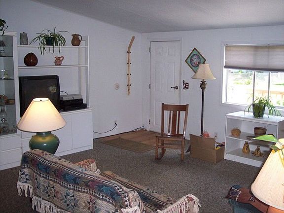 Enter into the living room with a wood floor entry and capeted living room.
