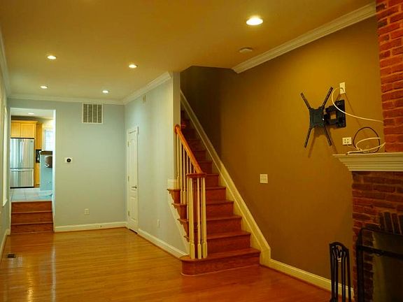 Living room with fireplace and space for your television with all wiring and hardware for swivel mount ready for you. Through the door at the end of the room is the large kitchen.