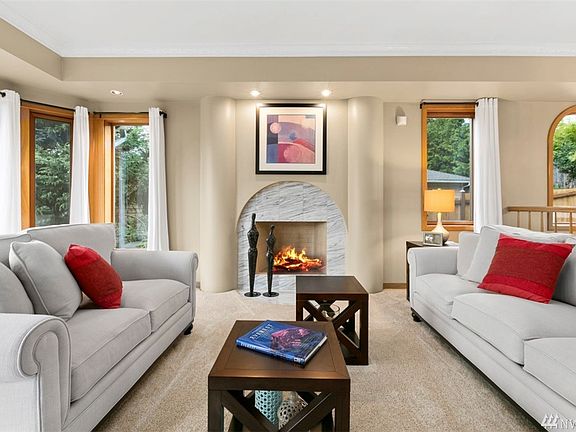Sunken Formal Living Room with Gorgeous Wood Fireplace, Light-Filled Windows, and Eye-Pleasing Architectural Details Including Rounded Fireplace Framing and Sunken Ceiling 