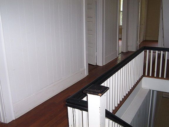 Hallway showing (from left to right) bathroom door, bedroom door, living room door, office at end of hall.