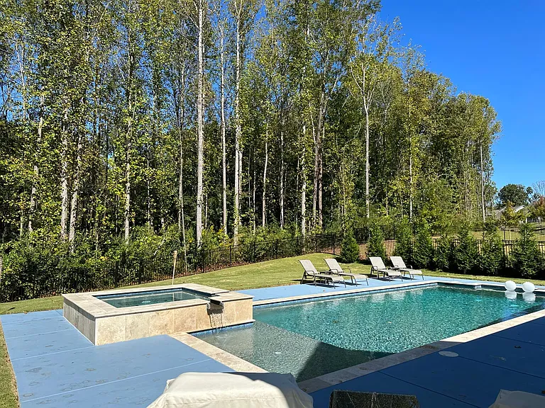 Heated salt water pool and hot tub with tanning deck and fountain