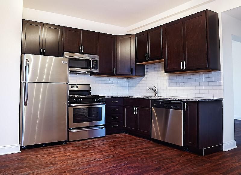 Kitchens features stone countertops and stainless steel appliances, including microwave and dishwasher