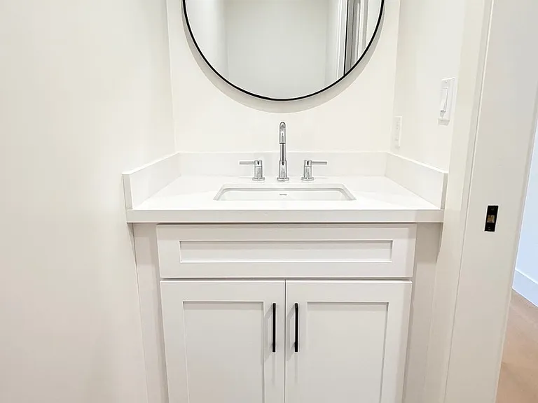 Stylish bathroom featuring decorative floor tile, modern fixtures, and a toilet area with a pocket door.