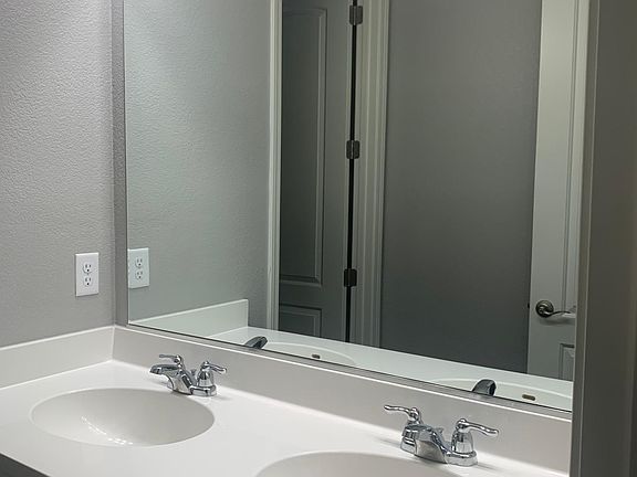 Dual sinks and a private shower/toilet area make busy mornings easier, allowing multiple guests or family members to get ready at the same time.