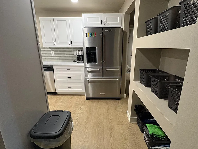 Efficient kitchen with shaker cabinetry, tile backsplash, and stainless French-door refrigerator with water/ice dispenser.