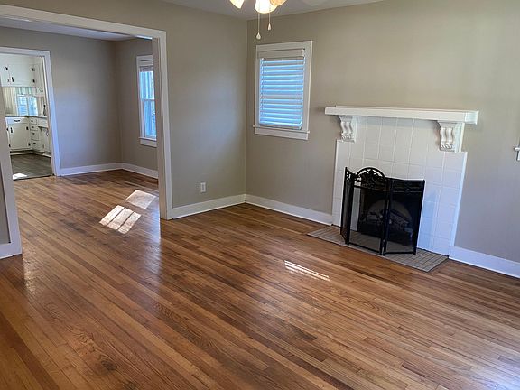Large living room with lots of natural light, ceiling fan, fireplace with adorable, original mantel. View to the dining room through to the massive kitchen and great room. FABULOUS for entertaining!