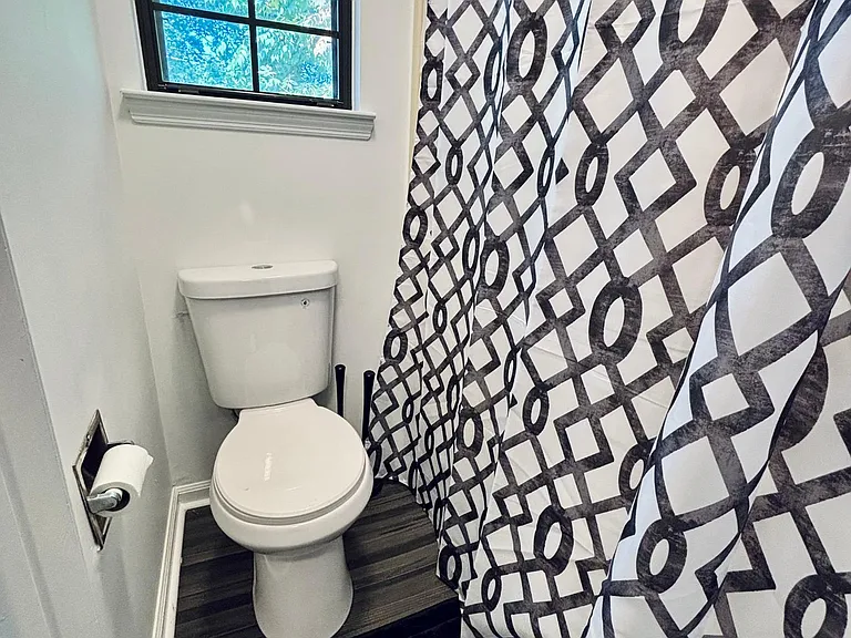 Bathroom with a window for natural light, shower/tub combo, and durable flooring in a clean, practical layout.