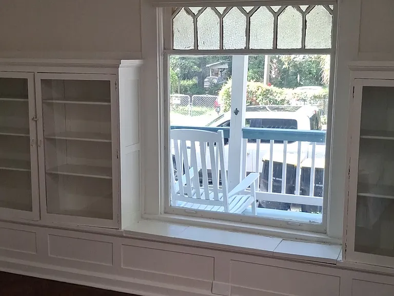 This available bedroom has a lovely bay window area with original decorative window and built-in bookcases.