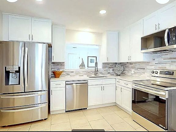 Bright, fully equipped shared kitchen featuring LG French door refrigerator, dishwasher, and quartz countertops