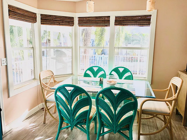DIning room with bay windows overlooking water.