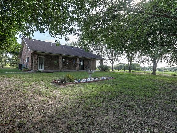 All brick custom home surrounded by majestic, manicured trees. Yard around home is fenced - perfect 