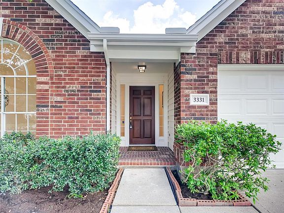 The covered brick front porch welcomes you in to this lovely home.