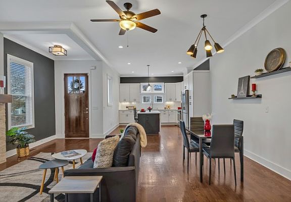 A view of the living and dining space and kitchen. Property is staged. Property comes unfurnished.
