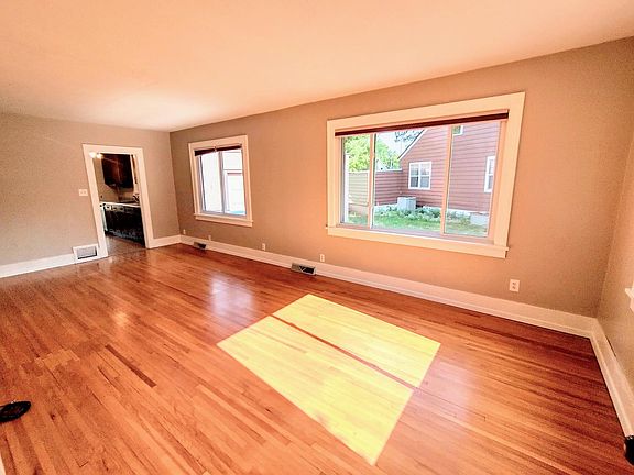 Large main floor living room, with original hardwood floors and lots of natural light.