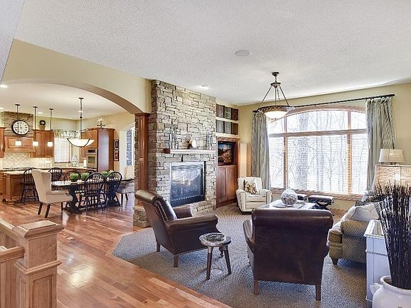 Beautifully designed great room w/ towering stone see-through fireplace. Large windows bring nature indoors.