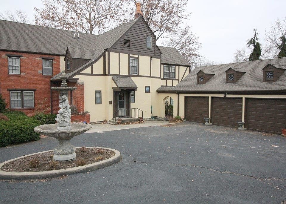 Side of house with 3 car detached garage and blacktop driveway