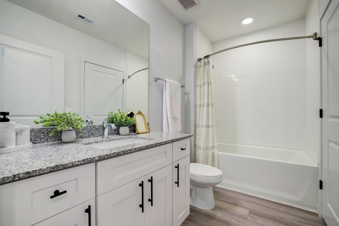 Lake Maggiore Apartments - Bathroom with white cabinetry and granite tops and soaking tubs - St. Petersburg, FL