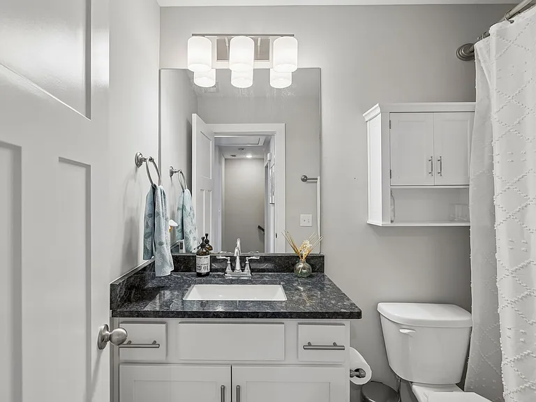 Full secondary bathroom with modern finishes and tub/shower combination.