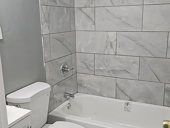 Brand new bathroom with new toilet, bathtub, vanity, floor, shower and shower surround