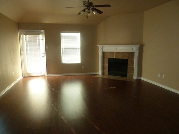Den, open to kitchen with faux wood floor, fireplace and cei