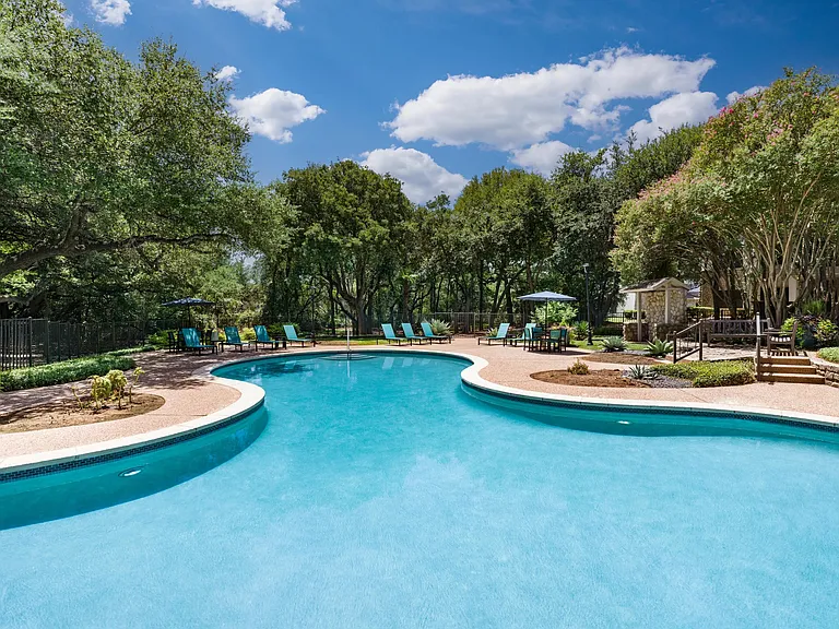 The sparkling resort-style pool is set against a backdrop of shade trees and tranquil seating_your go-to for relaxing afternoons.