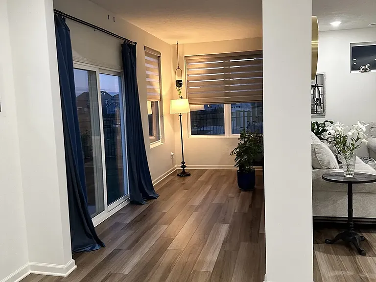 Extended sunroom with rear access to a scenic backyard featuring a lake view and deck_perfect for relaxing or entertaining