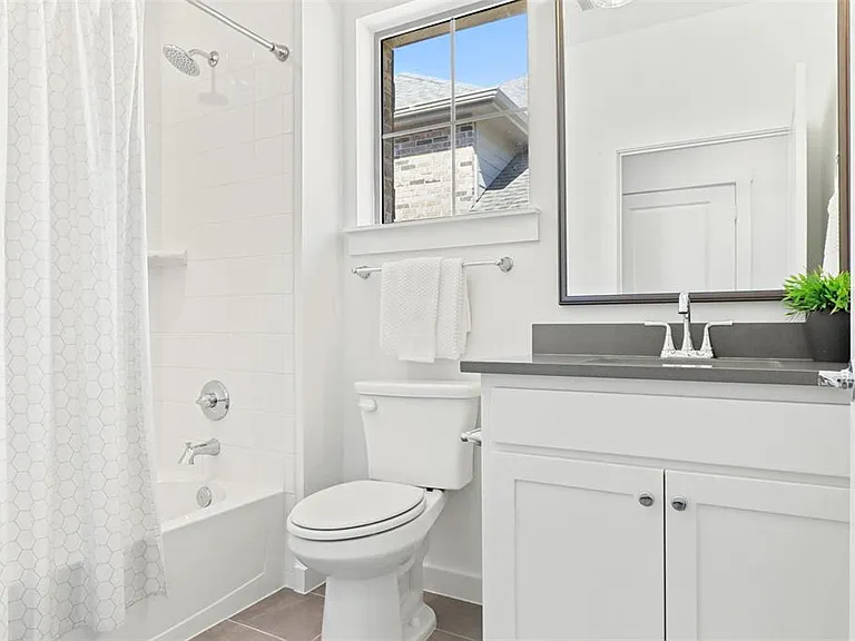 Spacious second bathroom, featuring relaxing rainfall shower head and a full shower/tub combination.