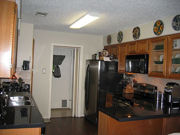 Kitchen with stainless appliances, updated countertops, sink, faucet and floor