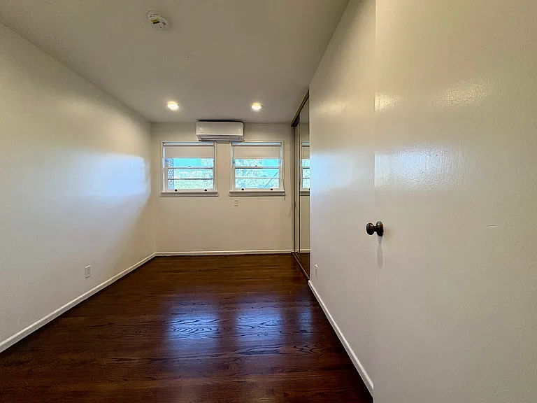 Second bedroom featuring split AC and mirrored closet.