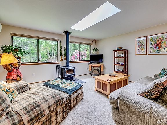 Entering the home, you are greeted by the light-filled living room with wall of windows facing the glorious back yard.  The wood stove provides cozy feel in the winter months.