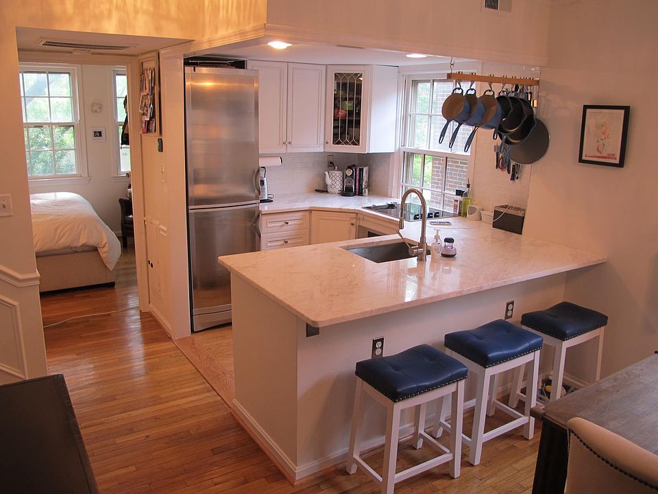 The kitchen with three breakfast bar stools. The space-saving pot/pan rack is provided as part of the lease.