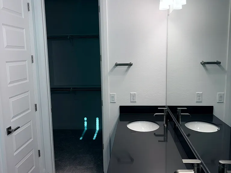 Master bathroom with baseboard lighting, separate toilet room.