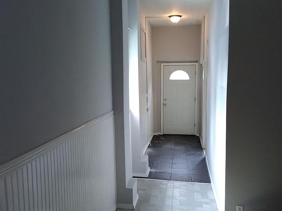 Entrance to apartment with hallway, steel insulated front door with deadbolt lock and half moon window to bring in natural lighting