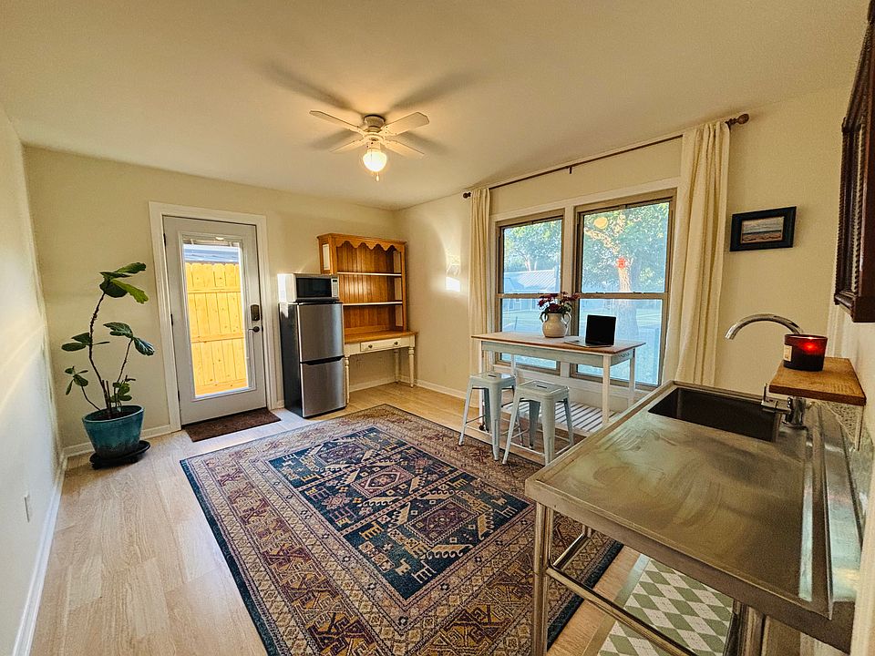 Flexible living area with dining table/kitchen island, pantry, sink, and kitchenette. Perfect for studying, cooking, or relaxing.