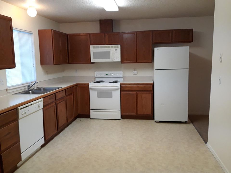 Spacious kitchen with refrigerator, microwave, dishwasher and range.