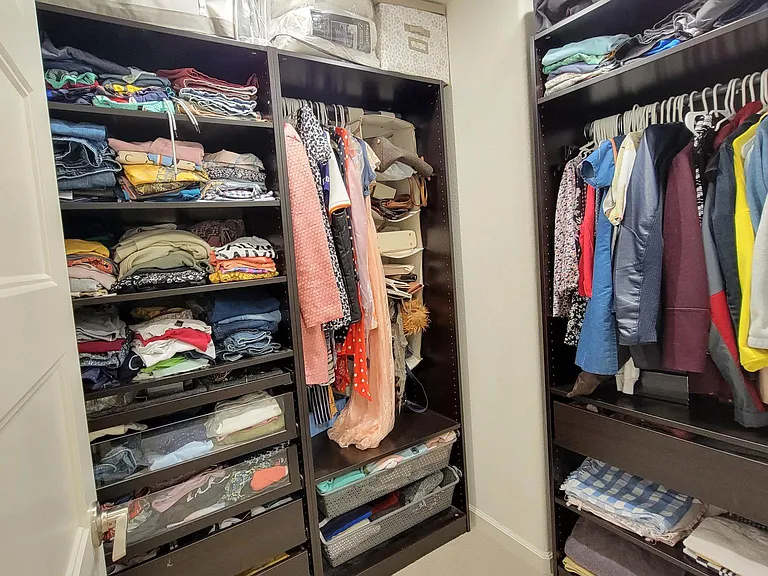 Furnished walk-in closet with lots of different types of storages solutions.