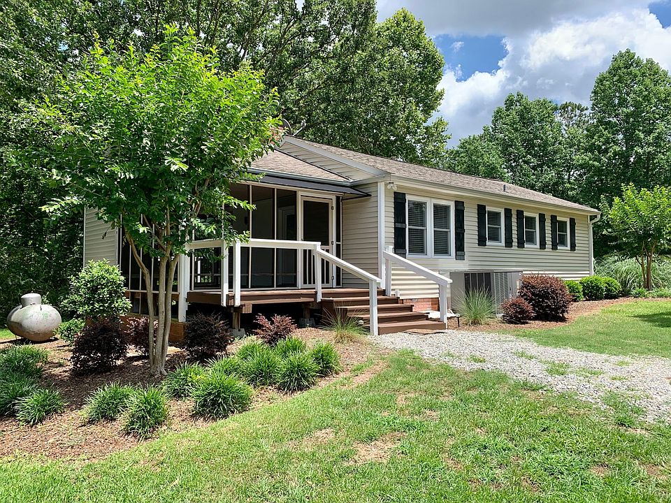 Front of house with large screened in patio and front balcony.