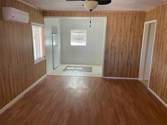 Living Room looking at kitchen and doorway to downstairs bathroom and bedroom.