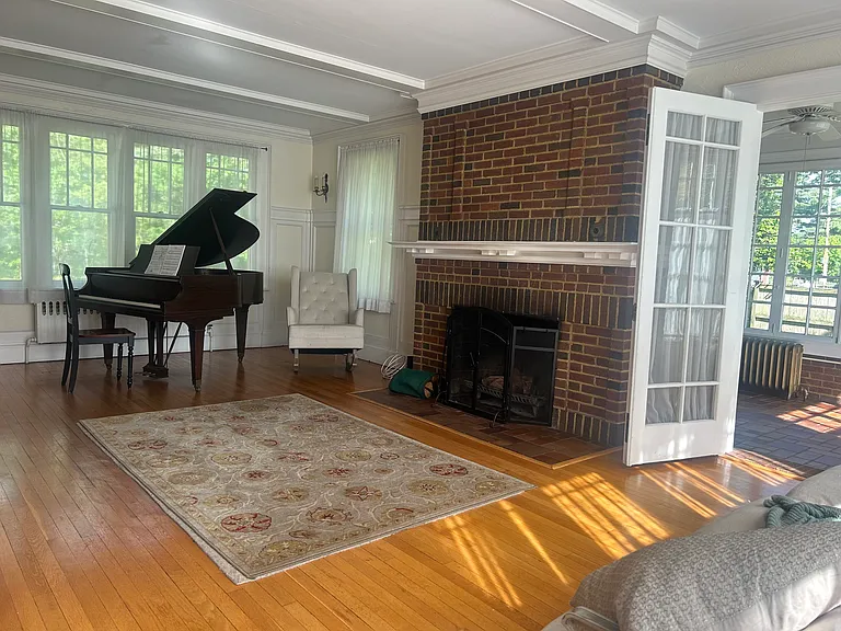 Living Room with active fireplace and well-maintained Baldwin grand piano.