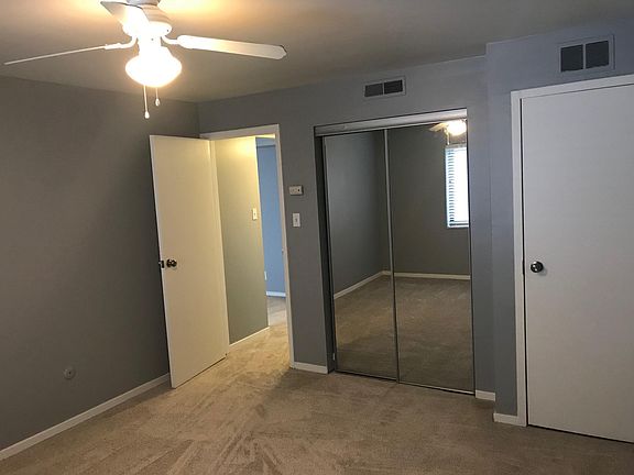 bedroom with fan and double mirrored closet