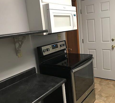 Kitchen with pantry, microwave, oven, refrigerator and dishwasher.