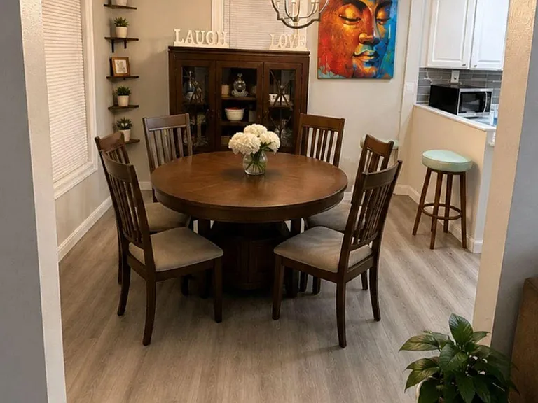 Dedicated dining area with a round table for six, statement lighting, and easy flow into the adjacent kitchen.